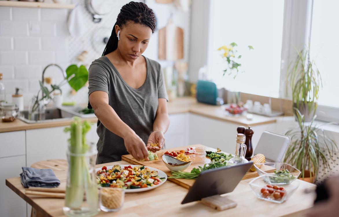 Vrouw kookt met verschillende ingredienten