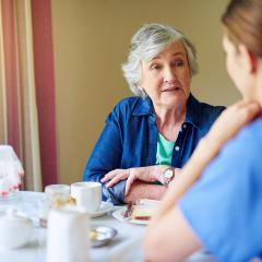 oudere vrouw en verpleegster aan tafel
